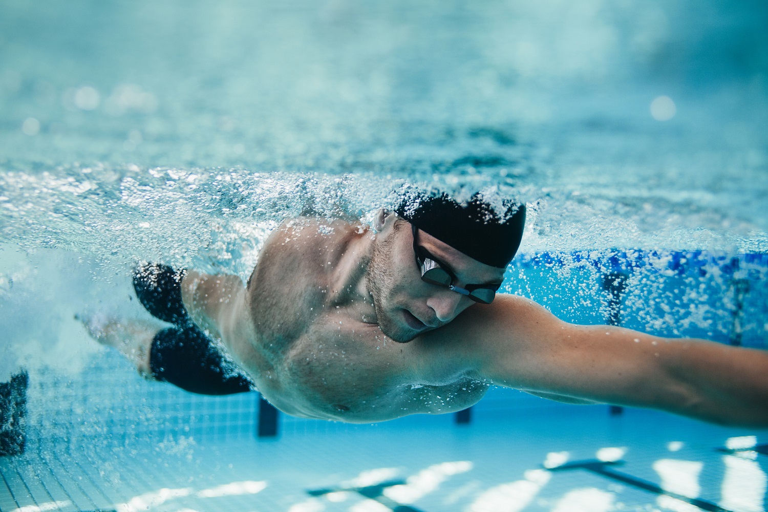 Fotografía subacuática de un nadador en forma entrenando en la piscina. Nadador profesional dentro de la piscina. Fotografía subacuática de un nadador en forma entrenando en la piscina. Nadador profesional dentro de la piscina.